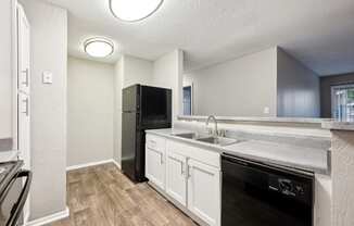 an empty kitchen with a sink and a refrigerator