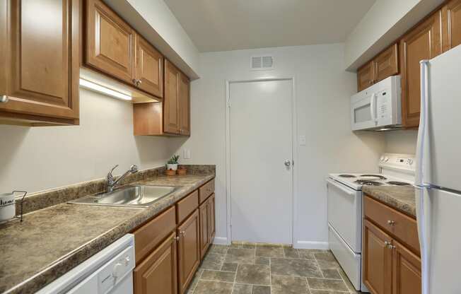 Mechanicsburg Apartments | Delbrook Manor Apartments | a kitchen with white appliances and brown cabinets