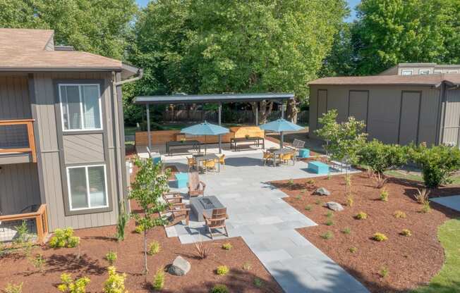 a backyard patio with umbrellas and tables