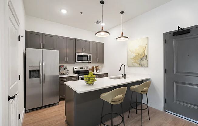 a kitchen with stainless steel appliances and an island with three stools