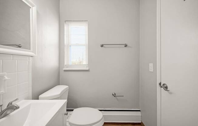 a bathroom with a toilet sink and a window