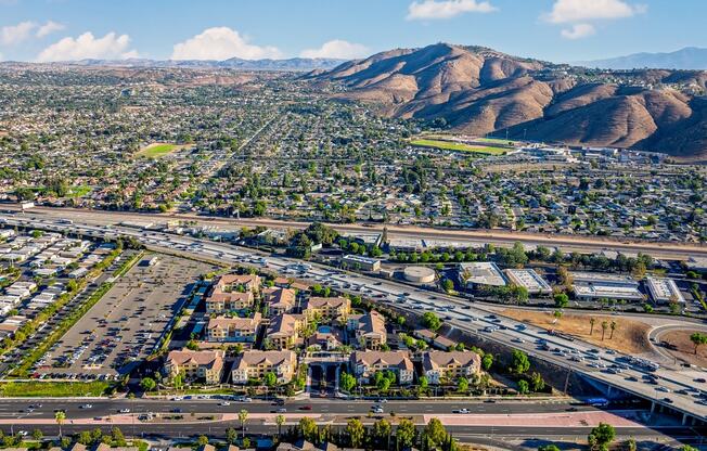 an aerial view of the city with highways and mountains