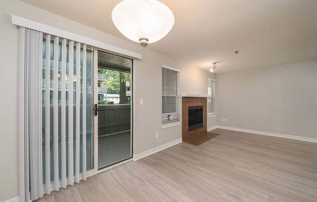 A room with a fireplace and sliding glass doors.