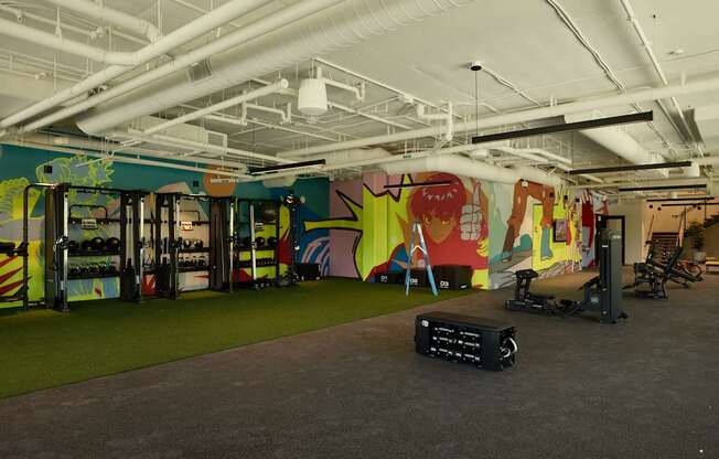A gym with a green floor and a wall with a mural.