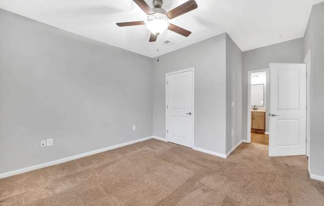 a living room with carpet and a ceiling fan