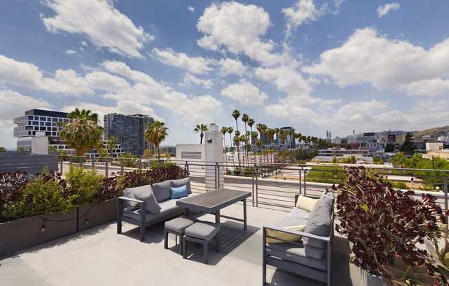 A patio with a table and chairs overlooks a cityscape.
