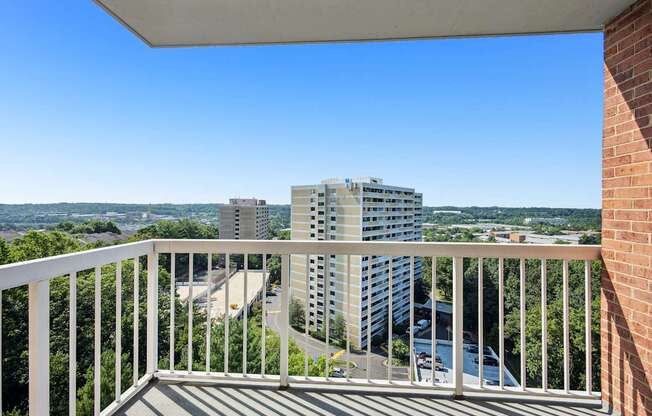 A balcony overlooks a cityscape with buildings and a river.