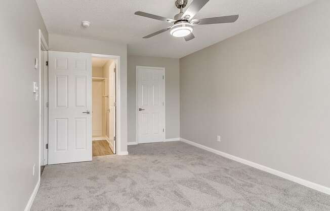 an empty living room with a ceiling fan