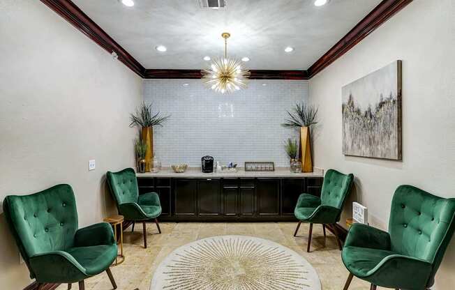 A waiting area with green chairs and a large artwork on the wall.