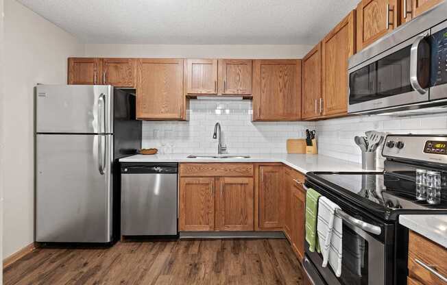 A kitchen with wooden cabinets and a black stove top oven.
