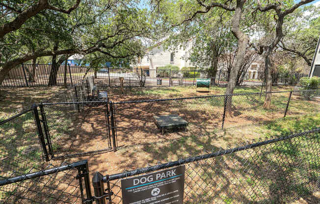A dog park sign is displayed on a fence.