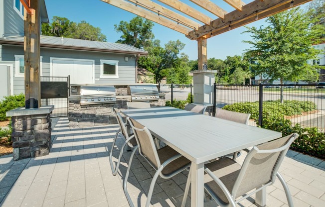 a dining area with a table and chairs under a pergola