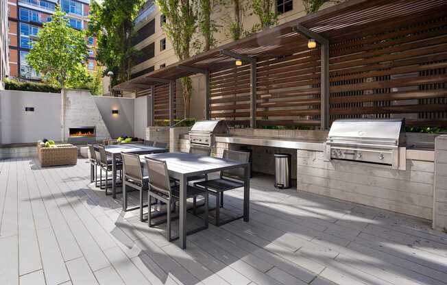 A patio with a table and chairs and a grill.