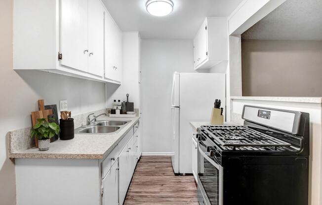 an empty kitchen with white cabinets and a stove and refrigerator