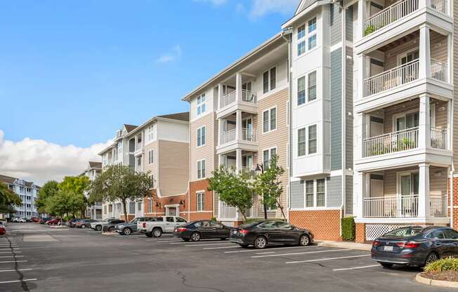 A parking lot with cars and apartment buildings.