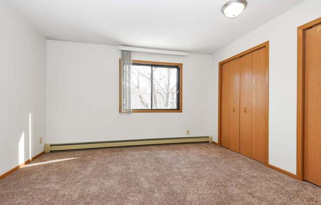 an empty room with carpet and a window and a door. Anoka, MN Dellwood Estates