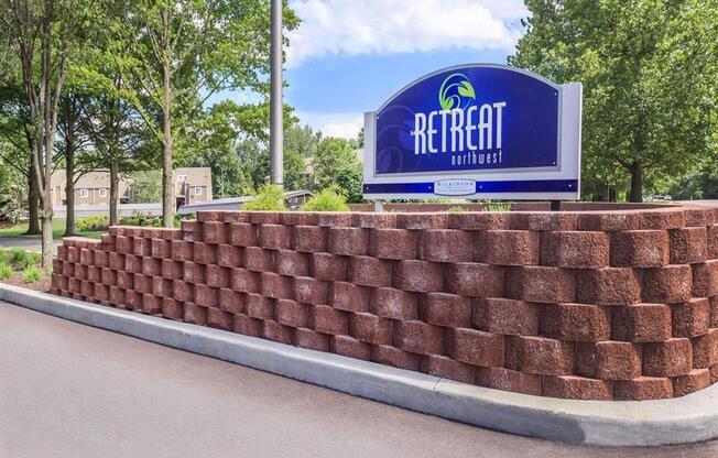 a brick retaining wall in front of a rehab rehab sign