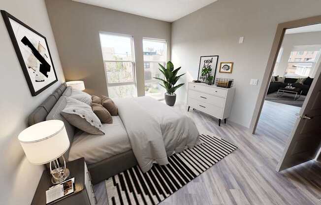 A bedroom with a bed, nightstand, and a plant.