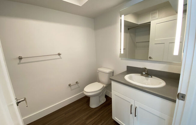 a bathroom with a white cabinetry and hard surface floors