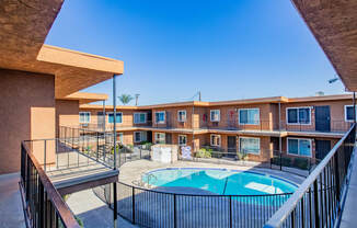 the outlook of a resort style pool with apartments in the background