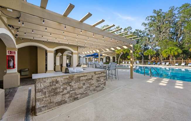 the pool area has a bar and a swimming pool with tables and chairs