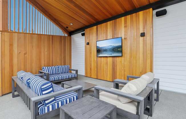 a patio with blue and white furniture and wooden walls