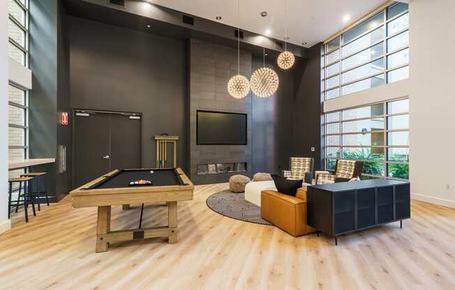 a living room with a pool table and a tv