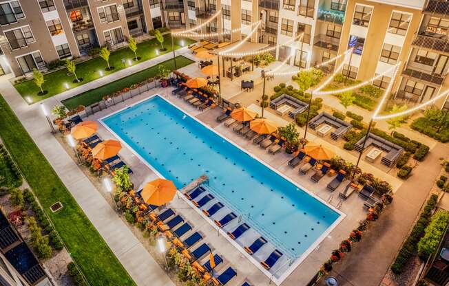 an overhead view of a swimming pool in front of an apartment building