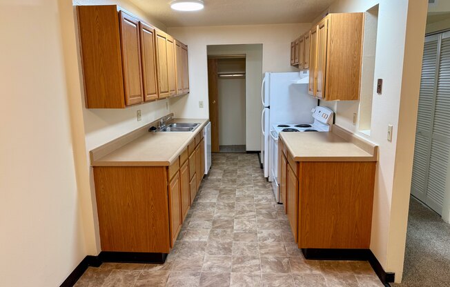 A kitchen with wooden cabinets and a tiled floor.