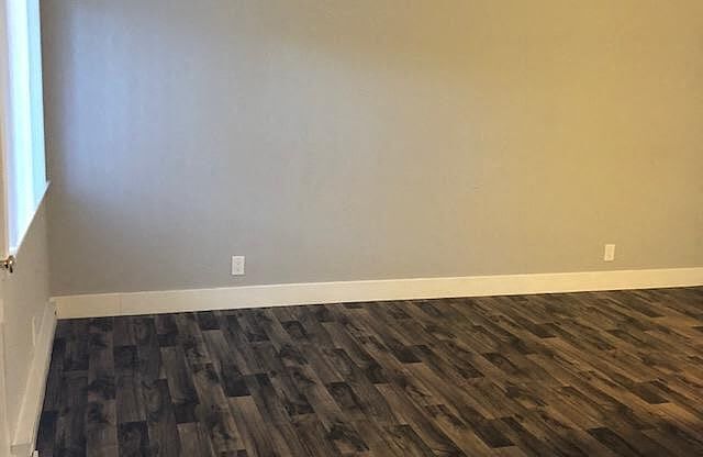 A room with a wooden floor and a white door.