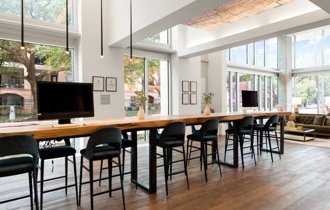 a dining room with a long table with chairs and a television