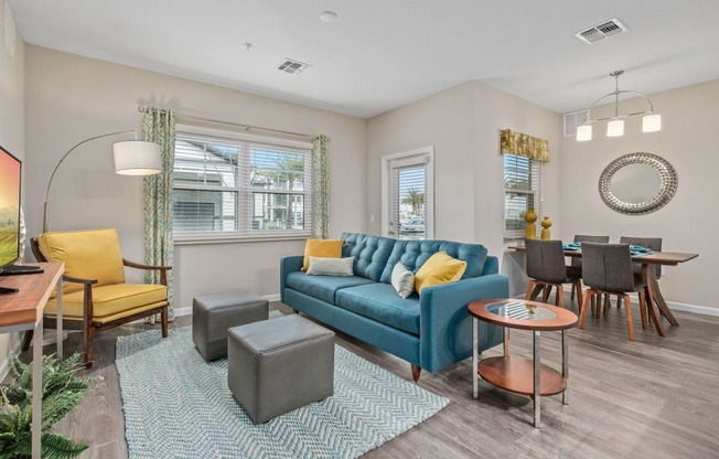 a living room with a blue couch and a dining room table
