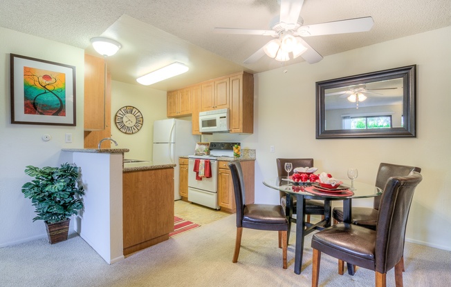 A kitchen with a dining table and chairs.