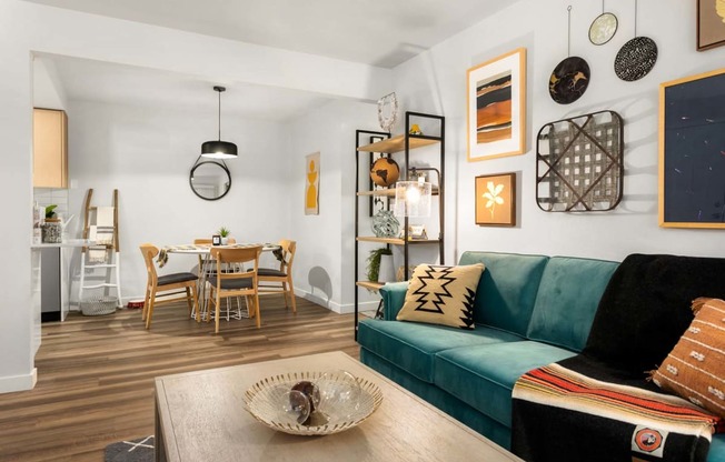 a living room with a green couch and a dining room table