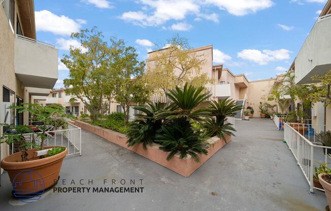 a courtyard with plants and apartments on both sides of a building