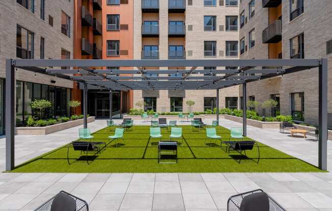 an outdoor lounge area with lounge chairs on a lawn at TREO Apartments, Cleveland, Ohio