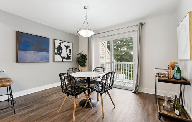 a dining room with a table and chairs and a sliding glass door that leads to a balcony at Linkhorn Bay Apartments, Virginia Beach, VA, 23451