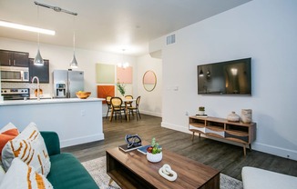 A modern living room with a green couch and a wooden coffee table.