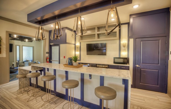 Communal kitchen with bar-style seating and TV at Lullwater at Blair Stone