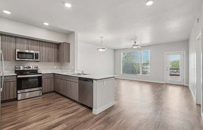 A spacious kitchen with wooden floors and modern appliances.