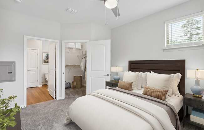 a bedroom with a large bed and a bathroom in the background Two Addison Place, Pooler GA