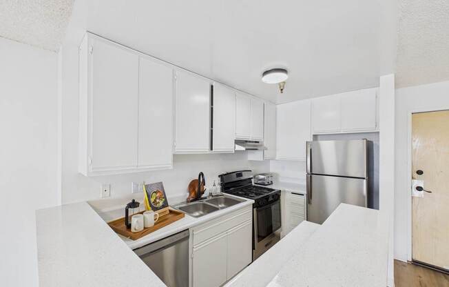 A kitchen with white cabinets and stainless steel appliances.