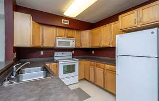 A kitchen with wooden cabinets and a white refrigerator.