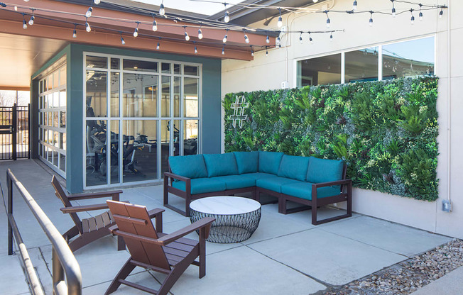 A patio with a sofa, chairs, and a table.