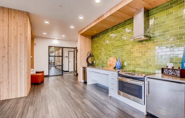 A kitchen with a green tiled wall and white appliances.at Holm at Sellwood, Oregon