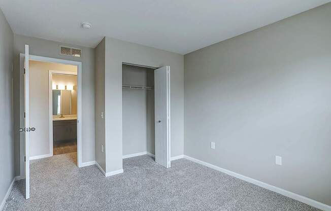 A spacious room with a carpeted floor and white walls.