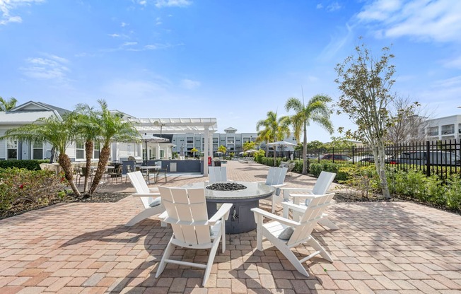 a communalm outdoor area with white chairs and a fire pit