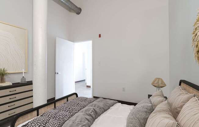The bedroom in the Mill House floor plan with a bed, nightstand, and a painting on the wall at Highland Mill Lofts in Charlotte, NC