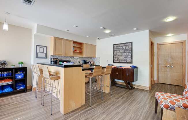 a kitchen with a bar and a dining area with stools
