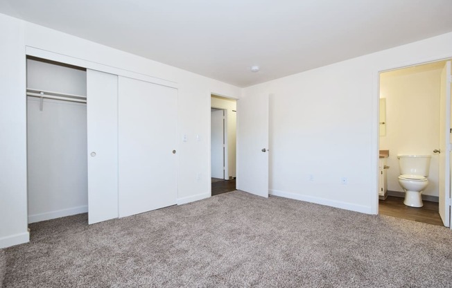 a bedroom with a toilet and two closets